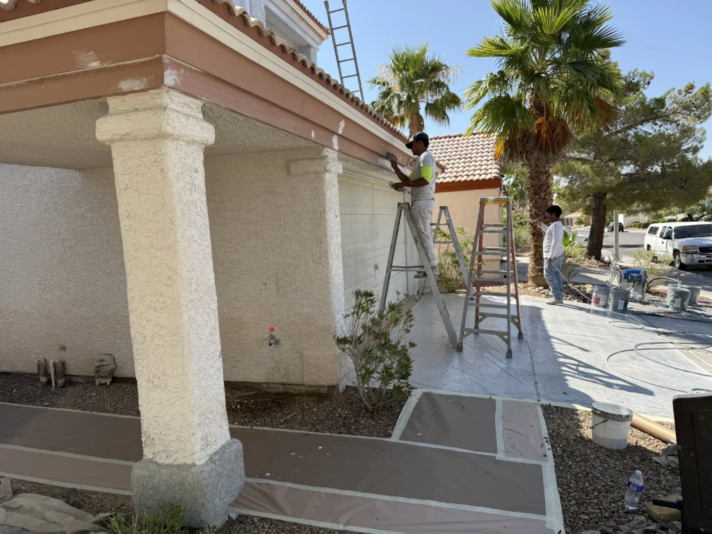 Exterior painting in Las Vegas, NV by Eclipse Painting showing professional painters on ladders refinishing a residential home exterior under the Nevada sun.